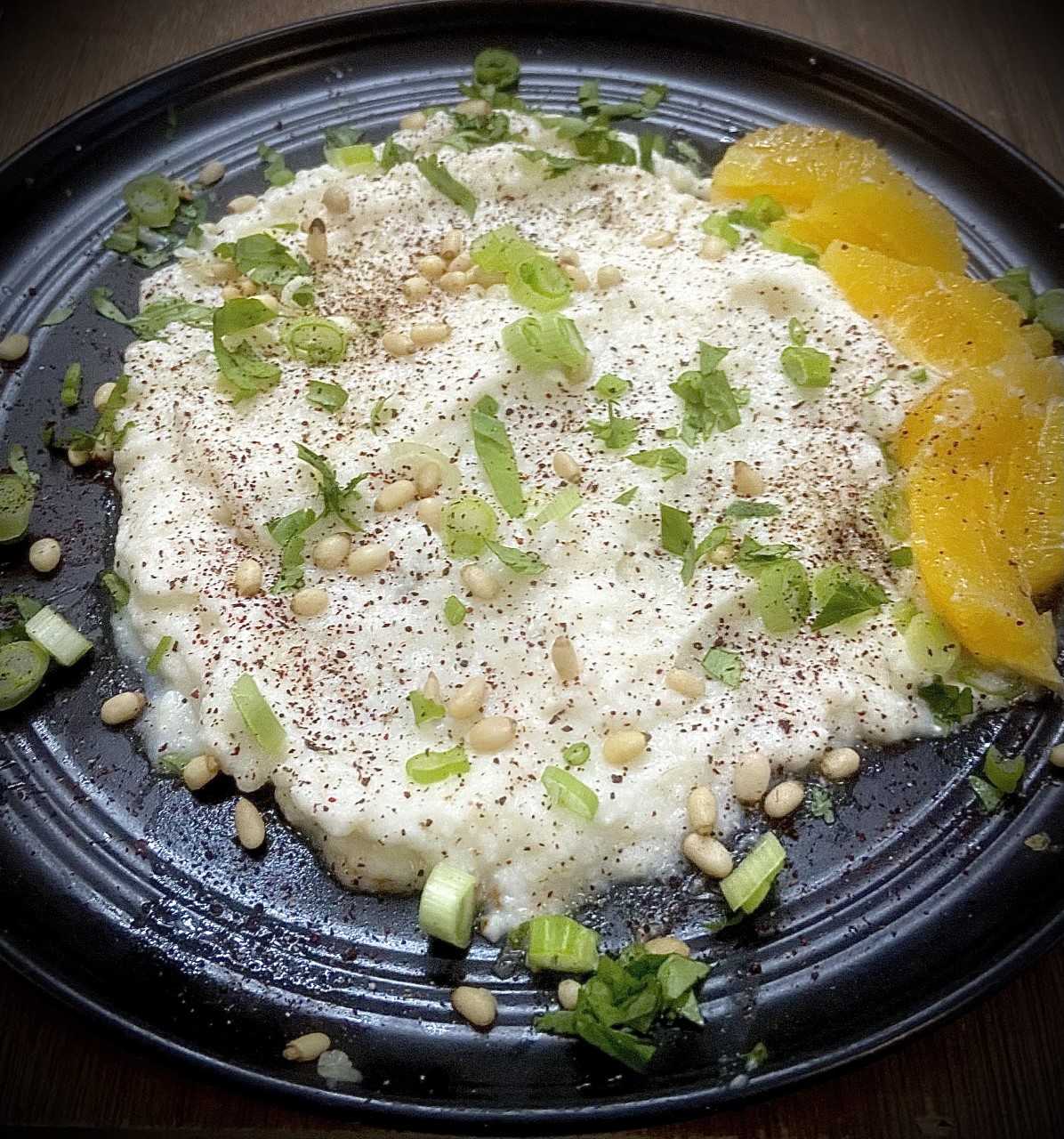 Elevated Cauliflower Purée with Roasted Garlic, Feta Cheese, Greek Yogurt, Pine Nuts, Oranges, and Sumac